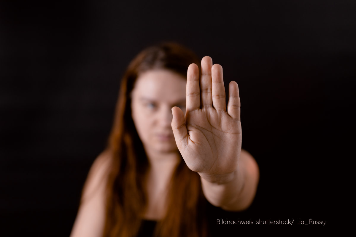Frau mit ausgestreckter Hand vor dunklem Hintergrund – Symbol für ein klares Nein in einer gefährlichen Beziehung