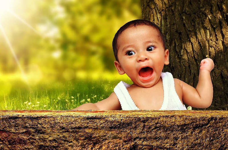 Empörtes Baby mit weit geöffnetem Mund vor einem sonnigen Hintergrund – Symbol für erlaubte, lebendige Gefühlsausdrücke beim Fluchen